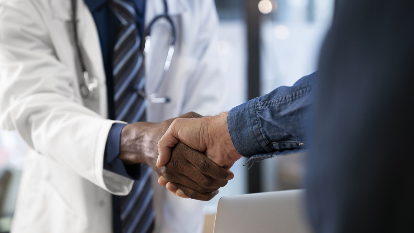 Doctor shakes hands with a patientd patient are at clinic